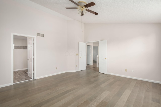 unfurnished bedroom featuring visible vents, wood finished floors, a spacious closet, and a textured ceiling
