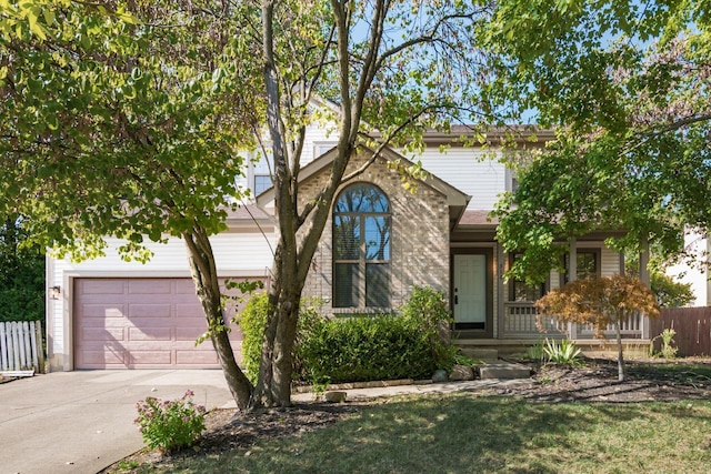 traditional home with driveway, fence, and an attached garage