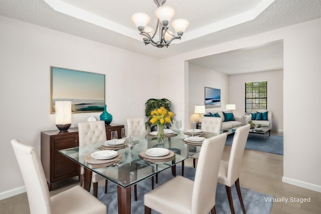 dining room featuring a textured ceiling, wood finished floors, and a notable chandelier