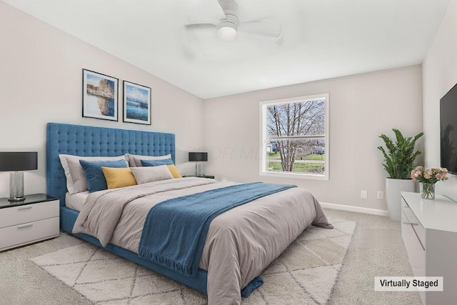 bedroom featuring ceiling fan, vaulted ceiling, baseboards, and light carpet