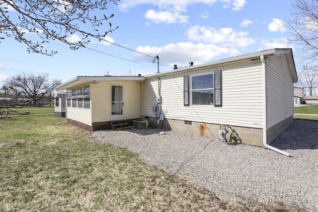 rear view of property with crawl space, a lawn, and entry steps