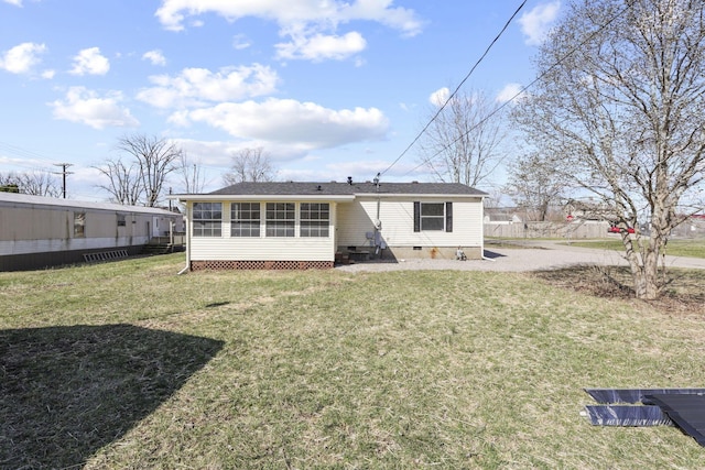 back of property with crawl space, a yard, and a sunroom