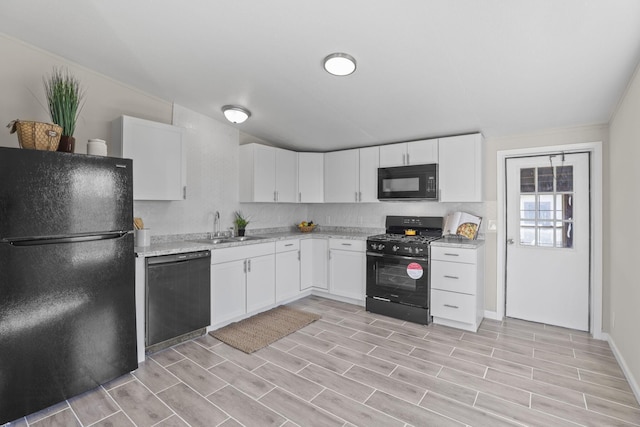 kitchen featuring white cabinetry, black appliances, wood finish floors, and a sink