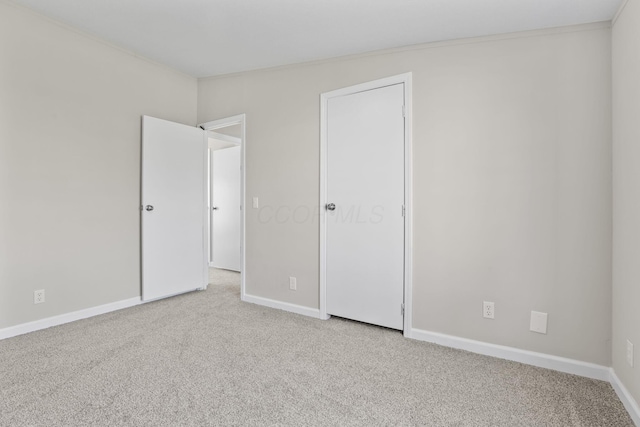 unfurnished bedroom with baseboards, carpet, and ornamental molding