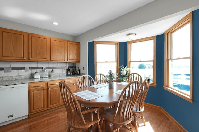 dining area with baseboards, light wood finished floors, and a wealth of natural light