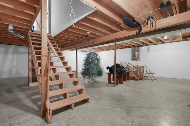 unfinished below grade area with electric panel and stairway