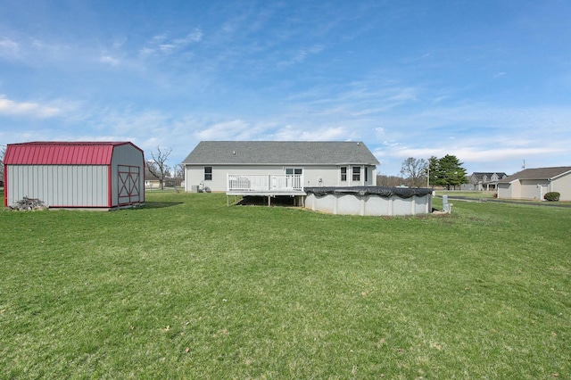 back of house featuring a lawn, an outbuilding, a covered pool, and a shed