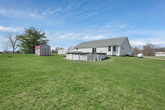 view of yard with an outdoor structure, a covered pool, and a shed