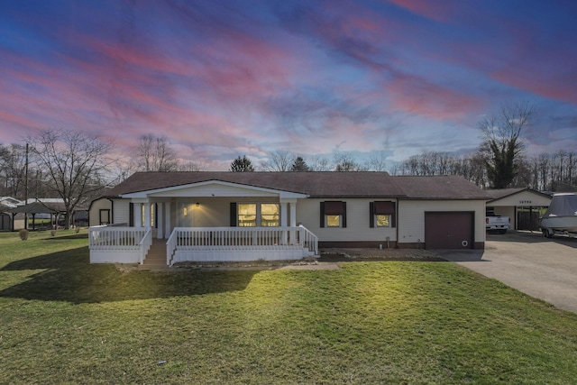 ranch-style home with a porch, an attached garage, a lawn, and concrete driveway