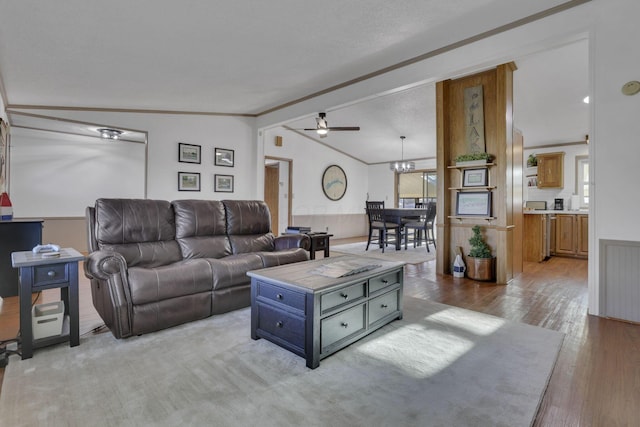 living room featuring a ceiling fan, lofted ceiling, plenty of natural light, and crown molding