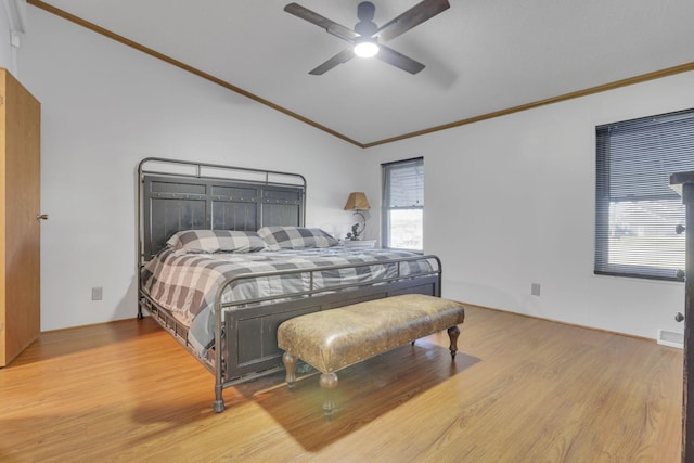 bedroom with light wood finished floors, crown molding, and lofted ceiling