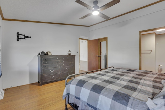 bedroom featuring light wood finished floors, crown molding, and ceiling fan