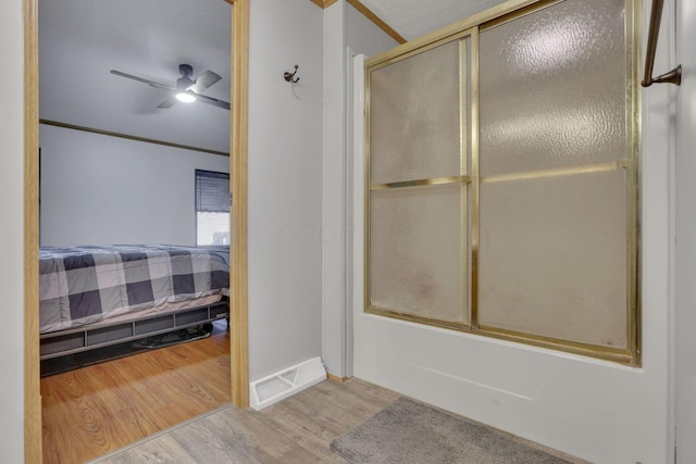 ensuite bathroom featuring visible vents, a ceiling fan, wood finished floors, connected bathroom, and crown molding