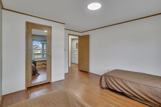 bedroom with crown molding and wood finished floors