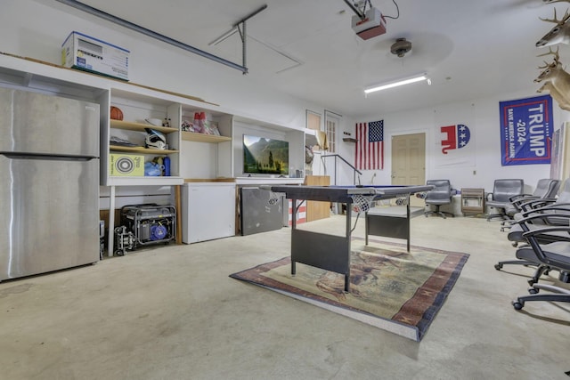 interior space featuring a garage door opener, freestanding refrigerator, and fridge