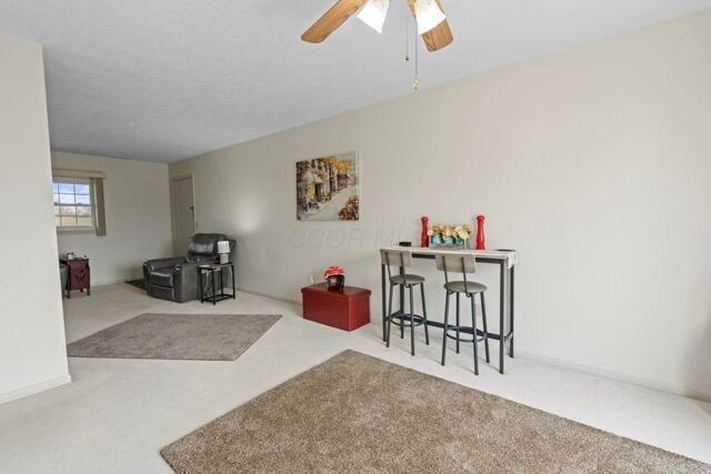 interior space with a textured ceiling and ceiling fan