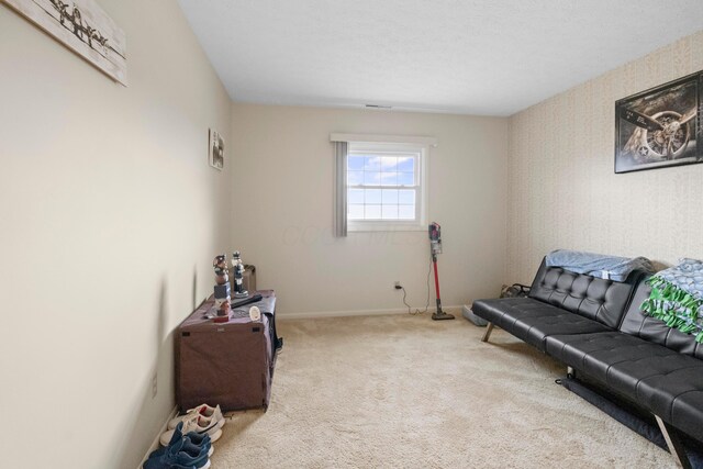 sitting room with baseboards and carpet floors