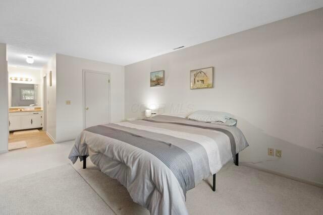 carpeted bedroom featuring ensuite bathroom