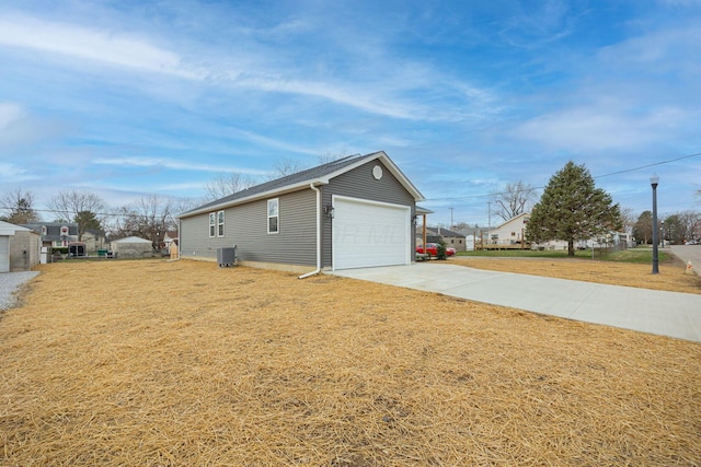 1651 Hillcrest Ave, Obetz, OH 43207 - view of side of home featuring cooling unit, a lawn, a garage, and driveway