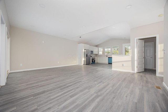 1651 Hillcrest Ave, Obetz, OH 43207 - unfurnished living room with baseboards, lofted ceiling, visible vents, and light wood-style flooring