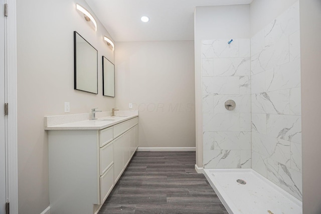 1651 Hillcrest Ave, Obetz, OH 43207 - bathroom featuring baseboards, double vanity, a tile shower, wood finished floors, and a sink