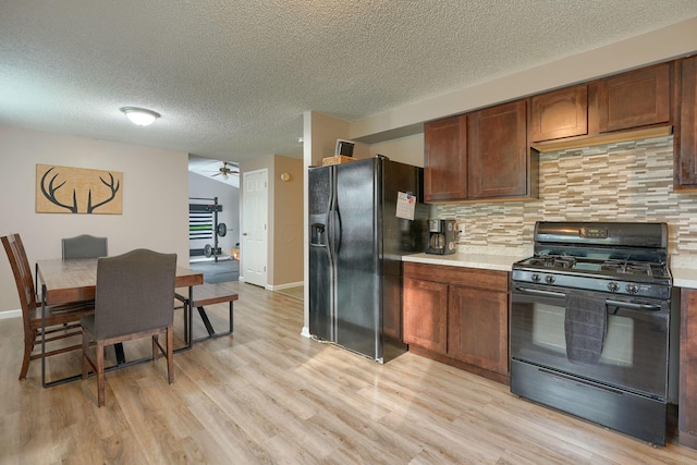 kitchen with light countertops, ceiling fan, black appliances, and light wood-type flooring