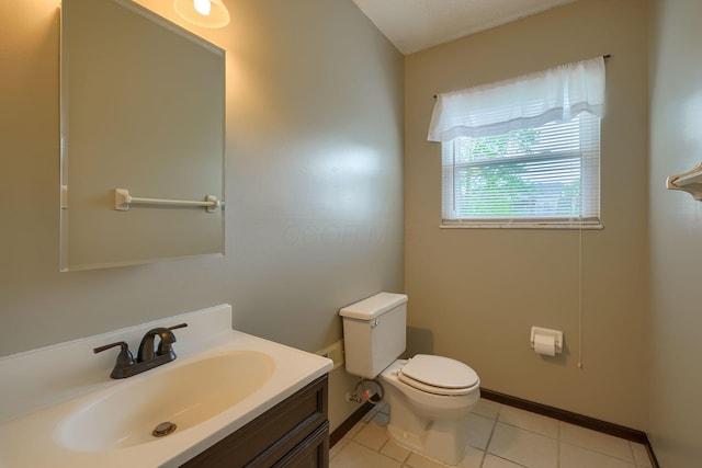 half bathroom with vanity, tile patterned flooring, and toilet