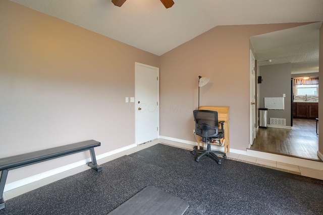 unfurnished office with baseboards, a ceiling fan, vaulted ceiling, and visible vents