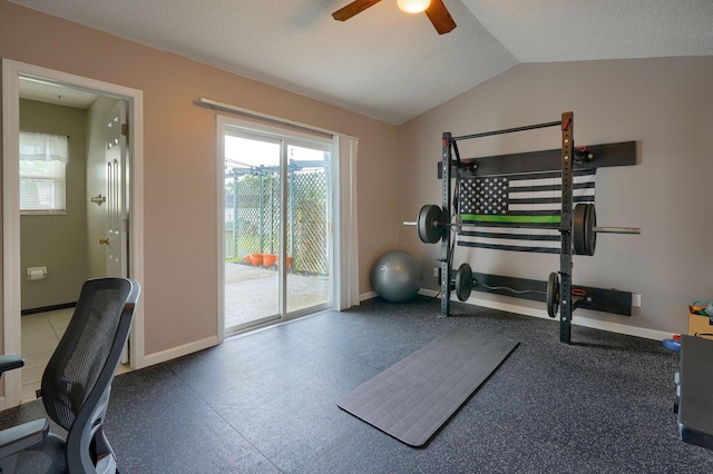 workout area with baseboards, ceiling fan, and vaulted ceiling