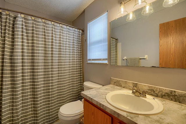bathroom featuring vanity, a textured ceiling, and toilet
