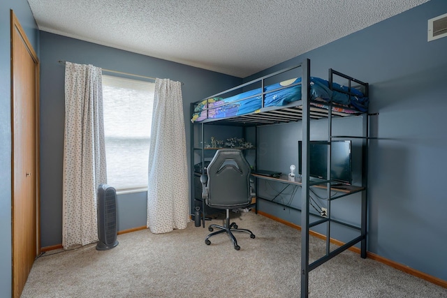 carpeted bedroom featuring baseboards and a textured ceiling