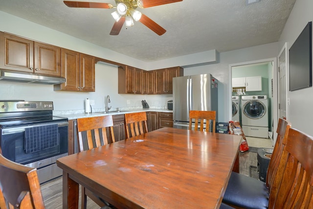 145 Danbury Rd, West Jefferson, OH 43162 - kitchen with light countertops, under cabinet range hood, washing machine and clothes dryer, a sink, and appliances with stainless steel finishes