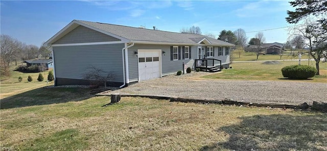 view of front of home featuring gravel driveway, a front lawn, and a garage