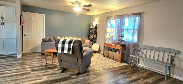 living area featuring wood finished floors, baseboards, and ceiling fan