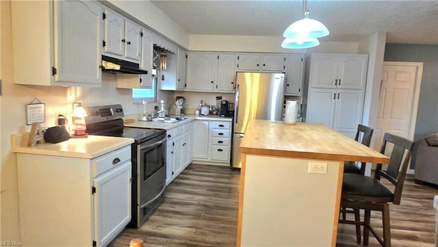 kitchen with under cabinet range hood, a sink, dark wood-style floors, stainless steel appliances, and a breakfast bar area