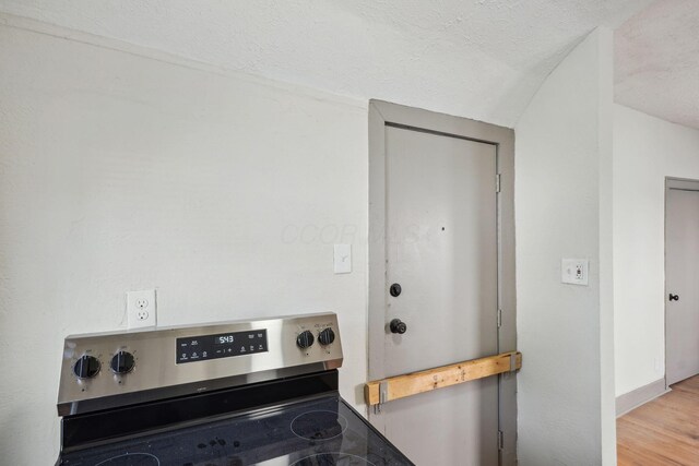 940 Leona Ave, Columbus, OH 43201 - detailed view of stainless steel range with electric stovetop, a textured ceiling, and wood finished floors