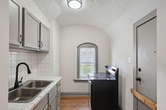 940 Leona Ave, Columbus, OH 43201 - kitchen with range with electric cooktop, a sink, dark wood finished floors, a textured ceiling, and decorative backsplash