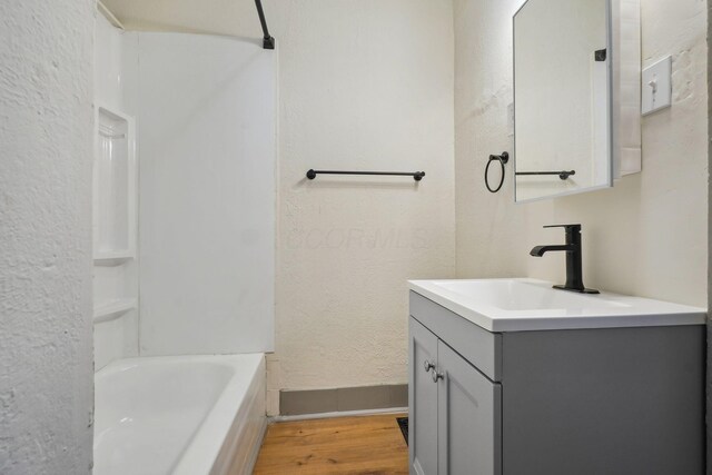 940 Leona Ave, Columbus, OH 43201 - full bath featuring wood finished floors, vanity, a textured wall, baseboards, and tub / shower combination
