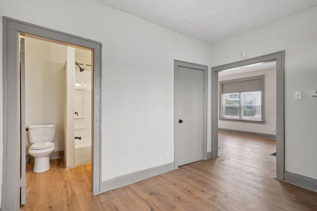 940 Leona Ave, Columbus, OH 43201 - unfurnished bedroom with light wood-type flooring, baseboards, ensuite bath, and a closet