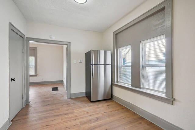 940 Leona Ave, Columbus, OH 43201 - kitchen featuring freestanding refrigerator, light wood-type flooring, baseboards, and a textured ceiling
