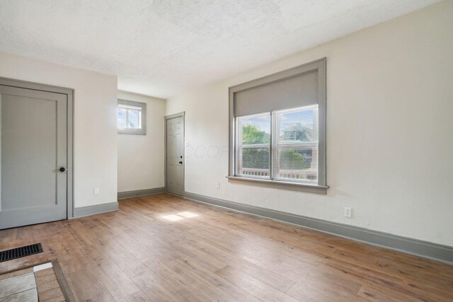 940 Leona Ave, Columbus, OH 43201 - unfurnished room featuring light wood-type flooring, baseboards, and a textured ceiling