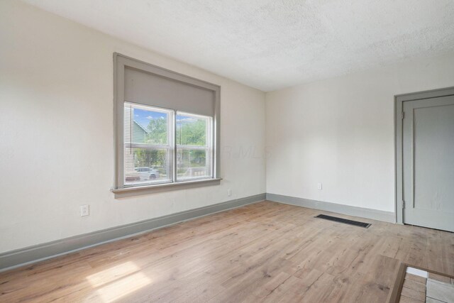 940 Leona Ave, Columbus, OH 43201 - empty room with wood finished floors, baseboards, and a textured ceiling