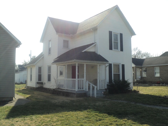view of front of house featuring a porch, roof with shingles, and a front lawn