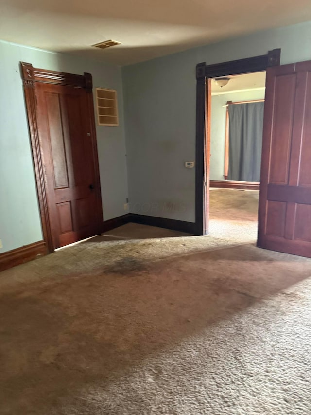 carpeted empty room with baseboards