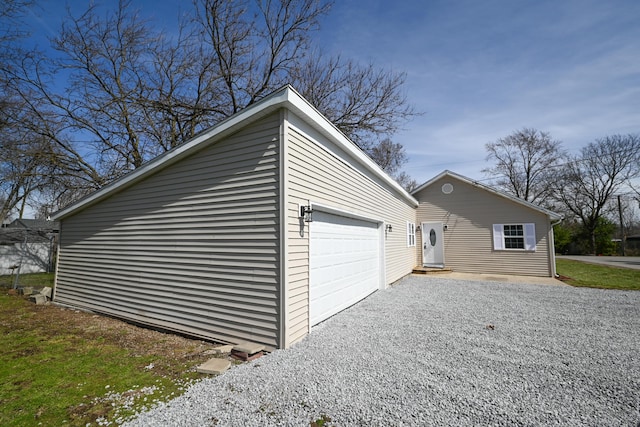 view of side of property featuring driveway and an attached garage