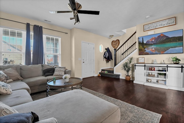 living room featuring stairway, a ceiling fan, wood-type flooring, baseboards, and visible vents