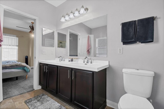 ensuite bathroom with ensuite bathroom, double vanity, toilet, and a sink