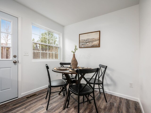 dining space with visible vents, baseboards, and wood finished floors