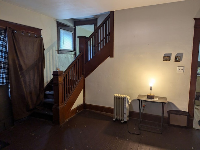 stairs with radiator, baseboards, and hardwood / wood-style flooring