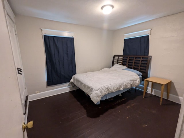 bedroom with baseboards and wood finished floors